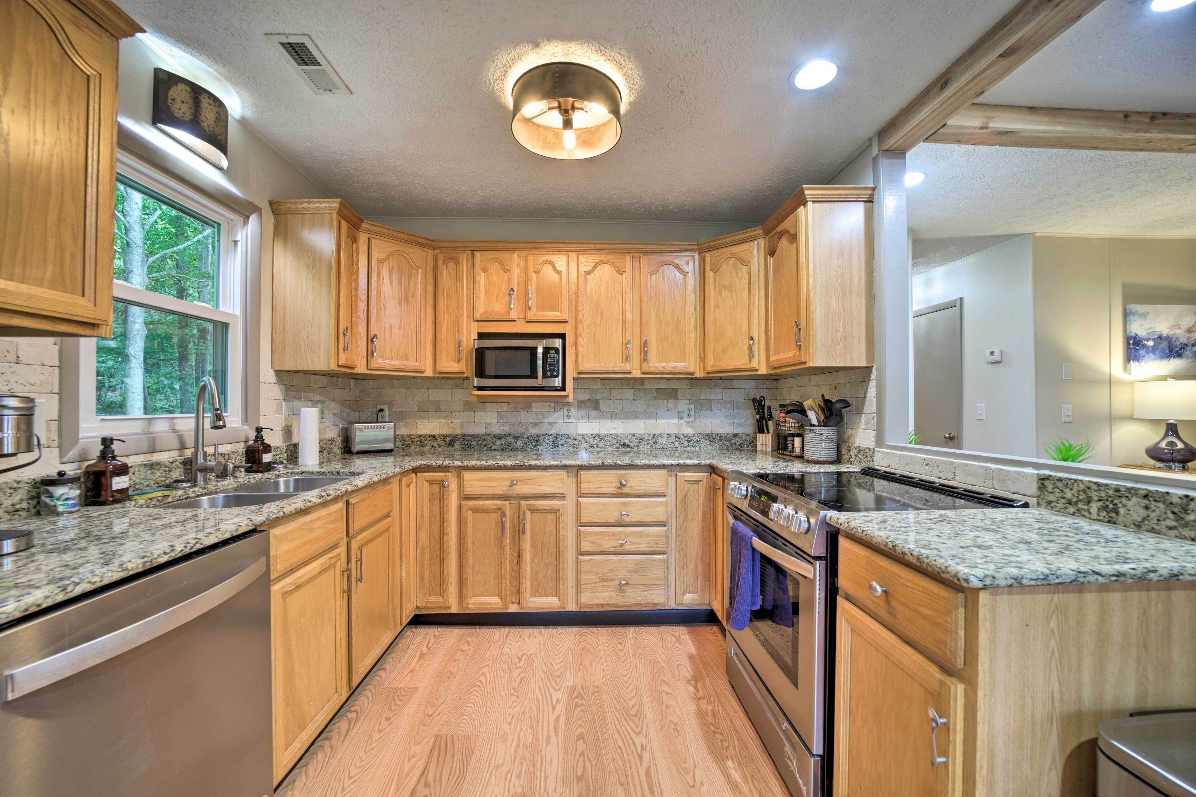 A kitchen with wooden cabinets, granite countertops, a microwave, and a dishwasher.