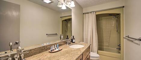 A bathroom with two sinks, a toilet, a shower, and a large mirror.