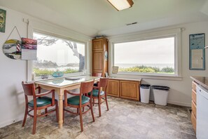 A kitchen with a view of the sea, a wooden cabinet, and a calendar.