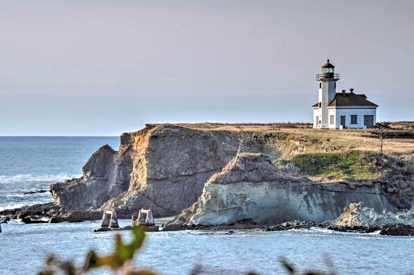 A lighthouse on a cliff by the sea.