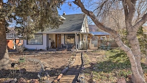 A house with a porch, a pathway, and a tree in the foreground. - Cozy & Vintage Cedar City Apartment w/ Fire Pit! (Cedar City)