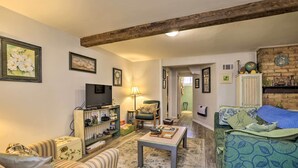 A cozy living room with a television, a sofa, a coffee table, and a patterned rug. - Cozy & Vintage Cedar City Apartment w/ Fire Pit! (Cedar City)