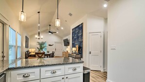 A modern kitchen with granite countertops, white cabinetry, and pendant lighting. - 4 Mi to Boat Ramp: Charming Rockport Home (Rockport)