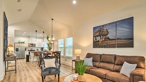 A spacious living area with a brown leather sofa, a round coffee table, and a dining area with chairs and a table. - 4 Mi to Boat Ramp: Charming Rockport Home (Rockport)