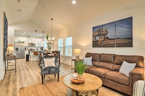 A spacious living area with a brown leather sofa, a round coffee table, and a dining area with chairs and a table. - 4 Mi to Boat Ramp: Charming Rockport Home (Rockport)