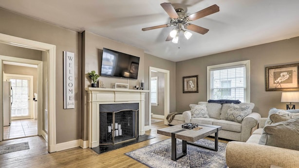 A living room with a fireplace, a sofa, a coffee table, and a television. - Chic & Cozy Greensboro Home, 2 Mi to Dtwn! (Greensboro)