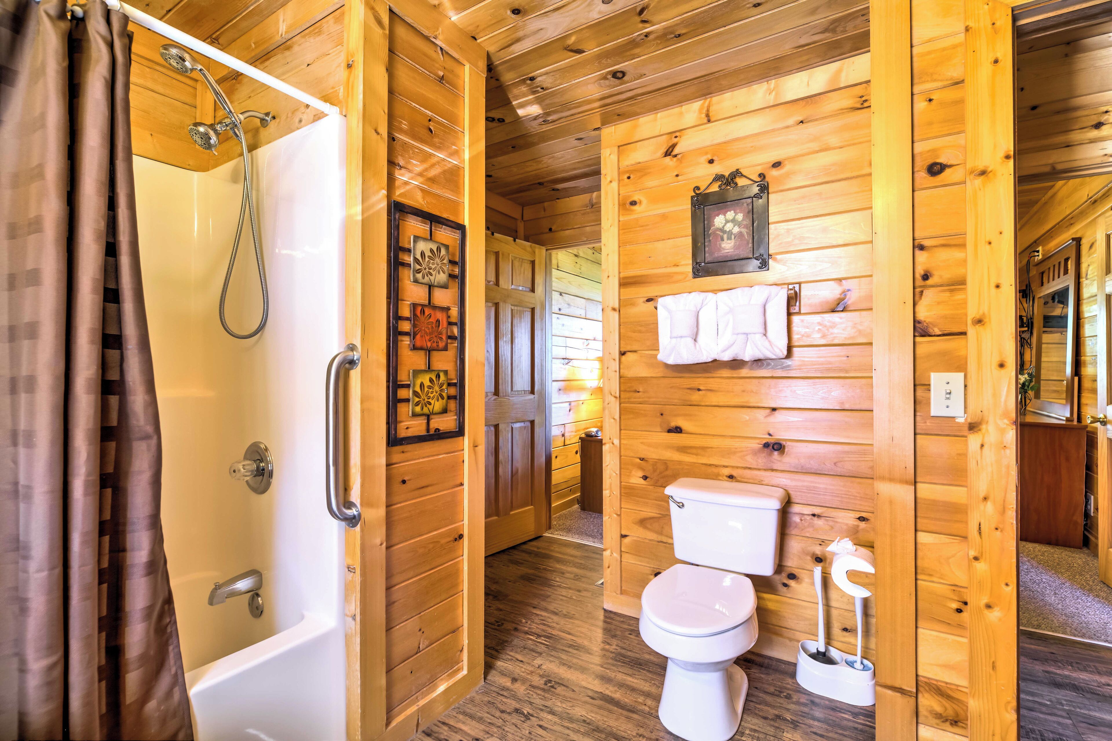 A wooden cabin bathroom with a shower, toilet, and a wooden door.