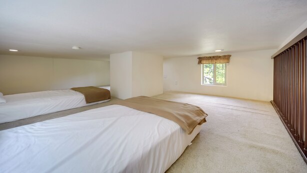 A room with two beds, a window with curtains, and a wooden wardrobe. - Cozy Fredericksburg Cabin With Shared Hot Tub! (Fredericksburg)