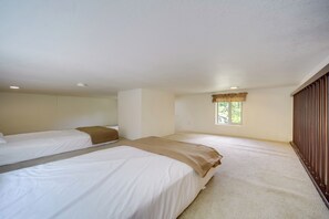 A room with two beds, a window with curtains, and a wooden wardrobe. - Cozy Fredericksburg Cabin With Shared Hot Tub! (Fredericksburg)