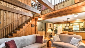 A cozy living room with two sofas, a wooden coffee table, and a staircase leading to a loft. - Black Mountain Cabin w/ Screened Porch + Views! (Black Mountain)