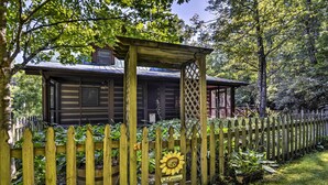 A rustic cabin with a wooden fence, a welcome sign, and a pergola structure. - Black Mountain Cabin w/ Screened Porch + Views! (Black Mountain)