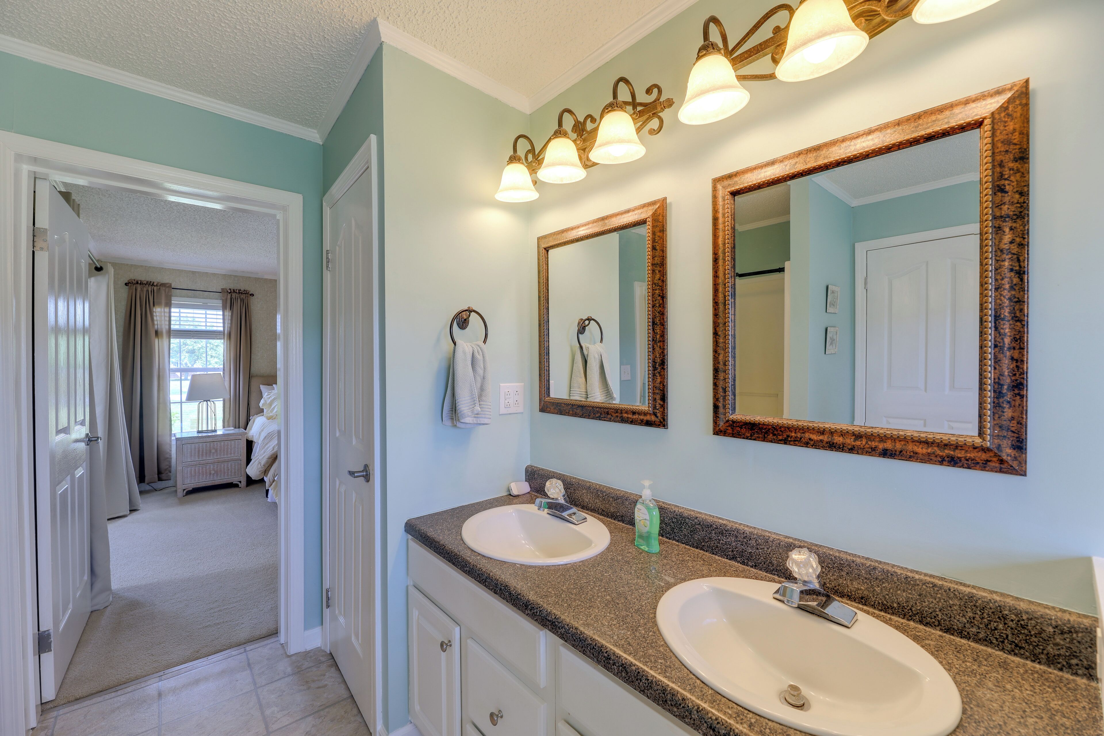 A bathroom with two sinks, a mirror, and a vanity.