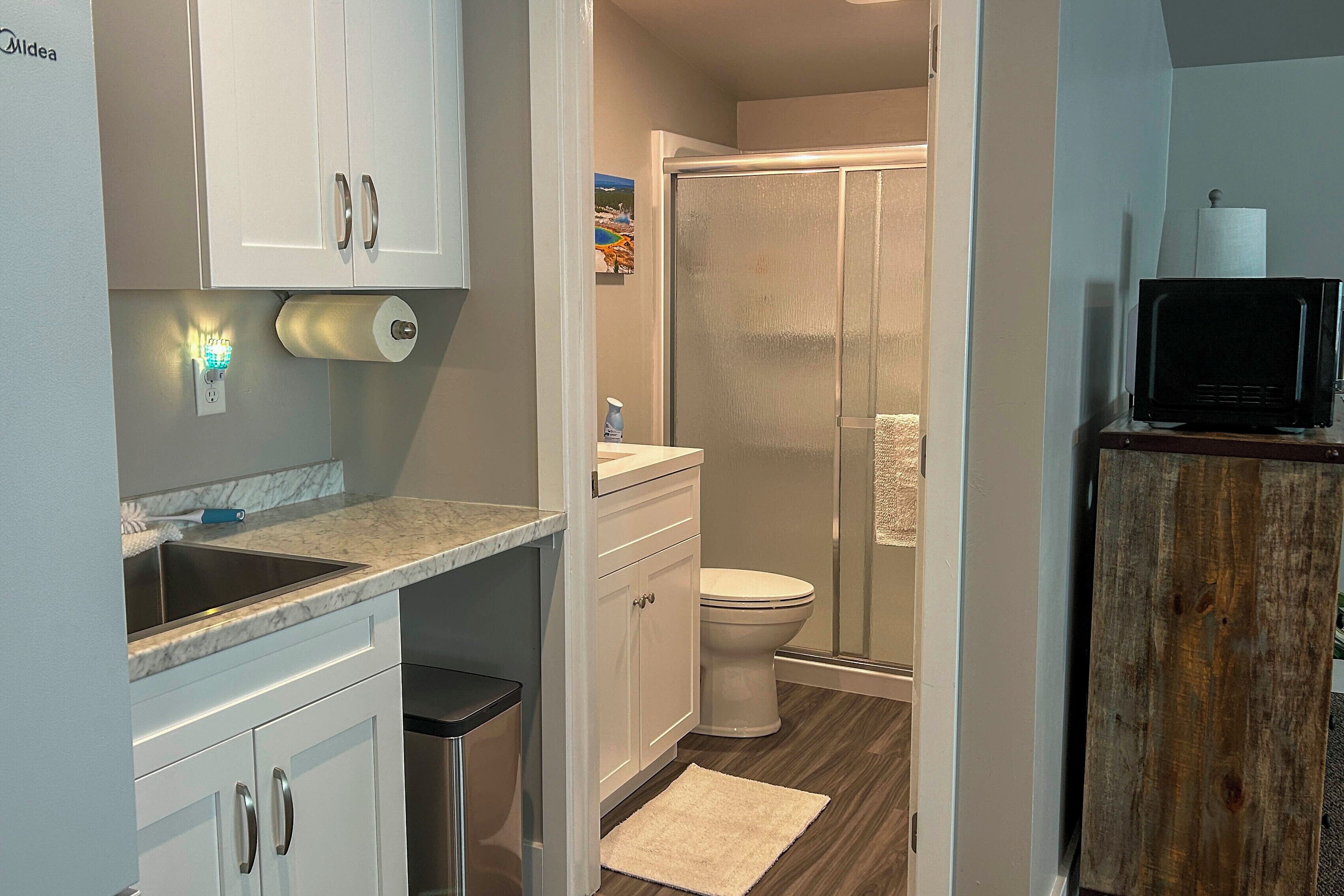 A compact bathroom with a shower, toilet, and sink.