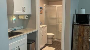 A compact bathroom with a shower, toilet, and sink.