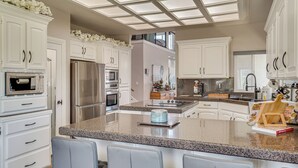 A modern kitchen with white cabinetry, stainless steel appliances, and a granite countertop.