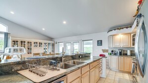 A spacious kitchen with granite countertops, stainless steel appliances, and wooden cabinets. - Inviting Great Falls Home w/ Wraparound Deck! (Great Falls)