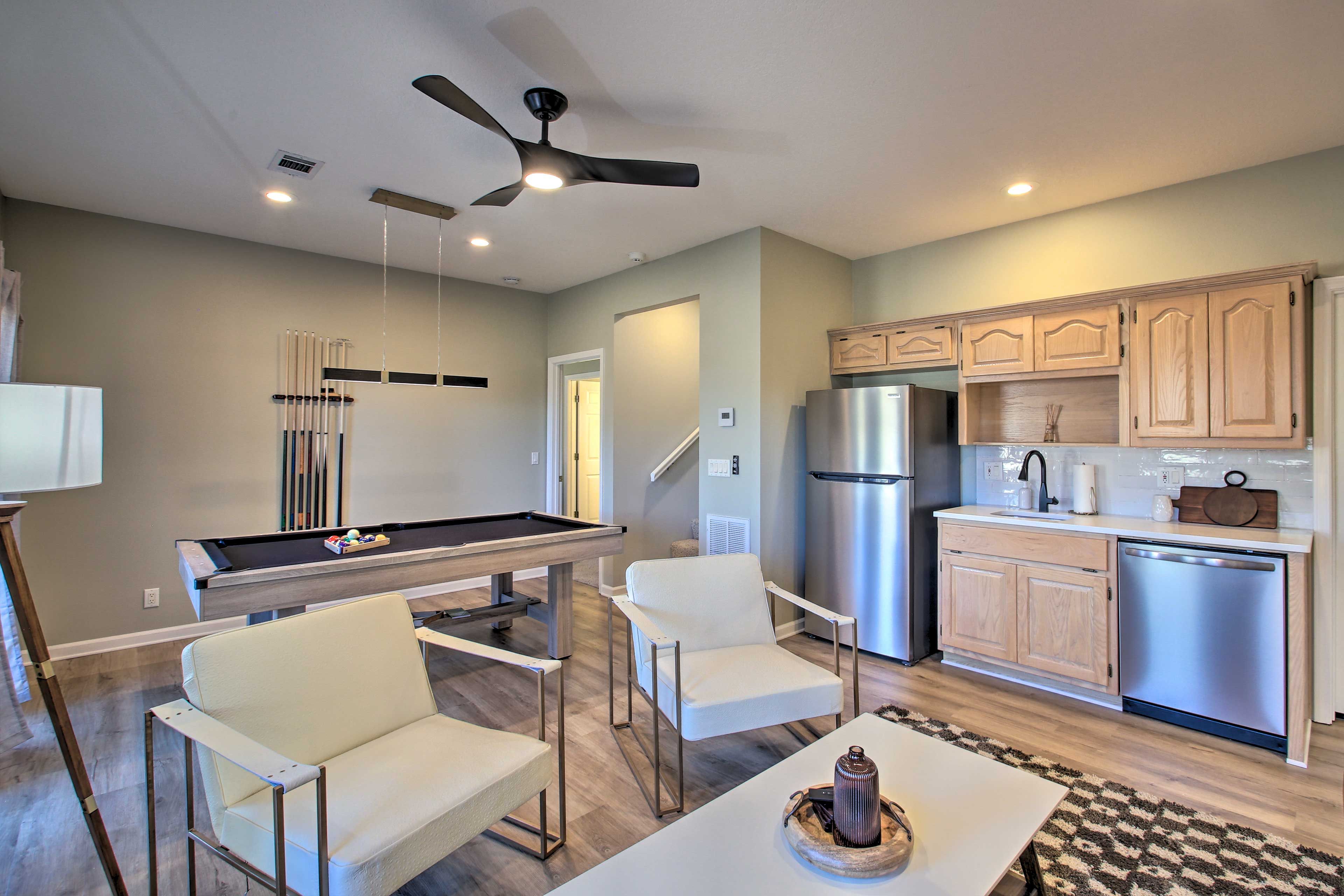 Una cocina moderna con lavavajillas integrado, refrigerador y mesa de billar.