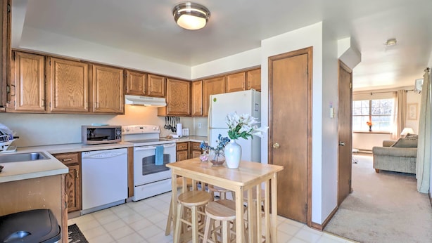 A kitchen with wooden cabinets, a microwave, an oven, a refrigerator, and a wooden table with stools. - 2 Mi to Dtwn Allentown Shops & Eats! Cozy Home (Allentown)