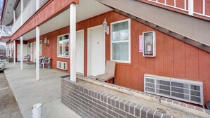 A two-story building with a red exterior, a covered front porch, and a fire extinguisher mounted on the wall.