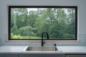 A kitchen with a large window, a stainless steel sink, and a wooden countertop. - Mtn Views: Colonial Home on Kingdom Trails! (East Burke)