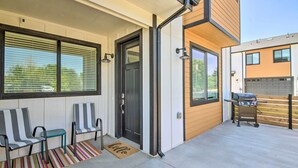 A modern house with a porch, a sliding door, and a barbecue grill.