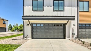 A modern two-story house with a garage, a driveway, and a well-maintained lawn.