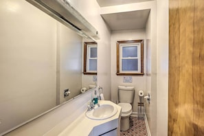 Ein kleines Badezimmer mit Waschbecken, Toilette und Spiegel.