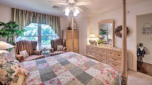 A bedroom with a large bed, a ceiling fan, a dresser, a chair, and a window with curtains. - 9 Mi to Midtown Harrisburg: Cottage w/ Deck (Harrisburg)