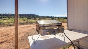 A portable stove on a white table outside a wooden structure with a view of a hilly landscape. - Charming Santa Rosa Home w/ Mountain Views & Porch (Santa Rosa)