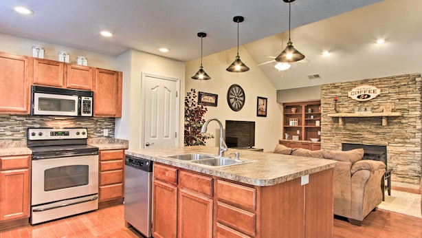A modern kitchen with granite countertops, stainless steel appliances, and wooden cabinets.