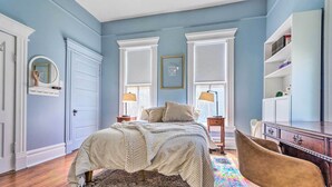Un dormitorio con cama, escritorio, silla y estantería.