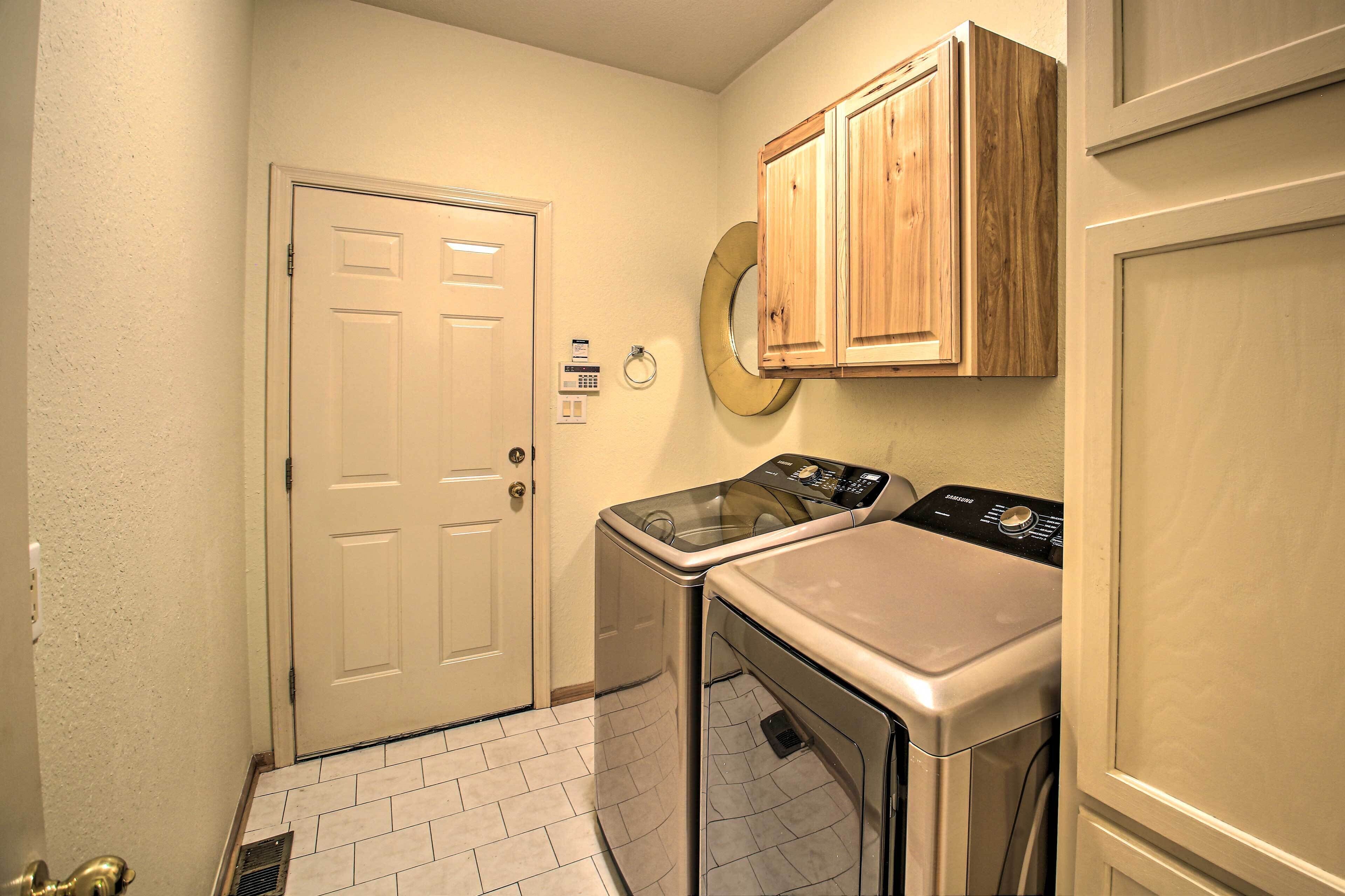 A laundry room with a door, a washing machine, and a dryer.