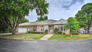 A two-story house with a garage, brick exterior, and a well-maintained lawn.