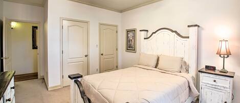 A bedroom with a bed, a nightstand, a dresser, and a ceiling fan.
