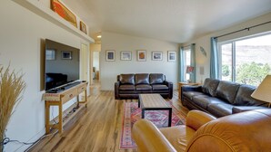 A living room with a TV, leather sofas, a coffee table, and a rug. - Moab House Near Arches Nat'l Park & Canyonlands! (Moab)