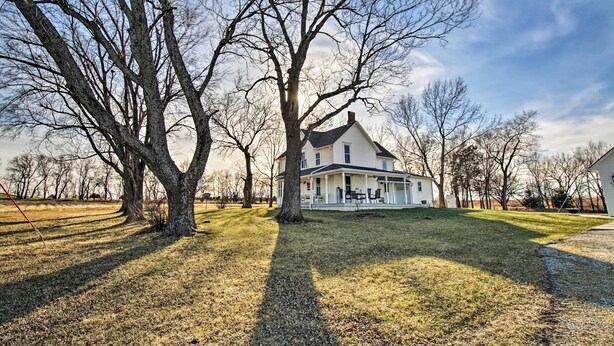A large, single-story house with a porch, surrounded by trees and a well-maintained lawn. - Lawrence Area Vacation Rental 15 Mi to Topeka! (Lecompton)