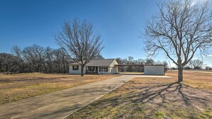 A single-story house with a front yard, a paved driveway, and a small shed.