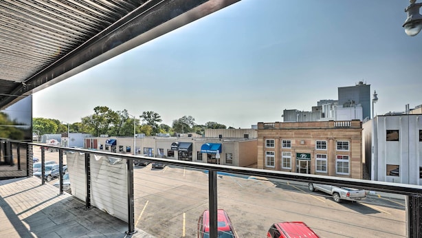 A parking lot with several cars, a building with a blue awning, and a clear sky. - Lake Norden Apartment w/ Spacious Balcony! (Lake Norden)