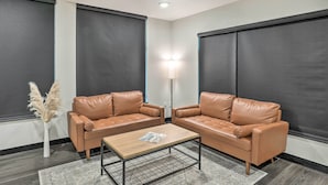 A modern living room with two leather sofas, a wooden coffee table, and a floor lamp. - Lake Norden Apartment w/ Spacious Balcony! (Lake Norden)