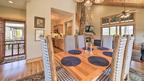 A dining area with a wooden table, checkered chairs, and a stone pillar. - Beautiful Lake Glenville Townhome w/ Mountain View (Cashiers)