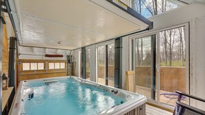A hot tub in a covered outdoor area with a view of the backyard. - Woodland Spa Sanctuary: Delaware Home w/ Swim Spa (Delaware)