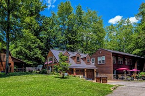 A residential area with multiple houses, a well-maintained lawn, and a clear blue sky.