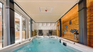 A hot tub with a wooden interior, large windows, and a ceiling light fixture. - Woodland Spa Sanctuary: Delaware Home w/ Swim Spa (Delaware)