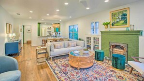 A spacious living room with a sofa, coffee table, and a fireplace. - Newly Updated & Charming Azalea District Home (Tyler)