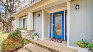A two-story house with a blue front door, a welcome mat, and potted plants on the porch. - Game Room + Large Backyard: Afton Home! (Afton)