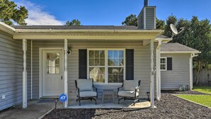 A house with a covered porch, two chairs, a small table, and a sign indicating a driveway. - Pet-friendly Jacksonville Home w/ Fenced Yard (Jacksonville)