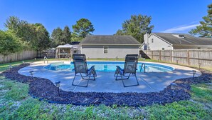 A backyard with a swimming pool, two lounge chairs, and a wooden fence. - Pet-friendly Jacksonville Home w/ Fenced Yard (Jacksonville)