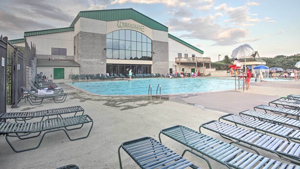 A pool area with lounge chairs and a building labeled "Woodstone Metals." - Resort Home on Mountain Golf Course w/ Deck & View (McGaheysville)