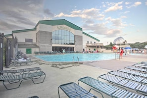 Un espace piscine avec des chaises longues et un bâtiment portant l’inscription « Woodstone Mezzanine ».