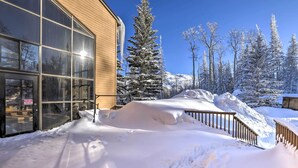 A snow-covered building with large windows, a wooden deck, and snow-laden trees in the background. - Resort-style Brian Head Condo Near Slopes! (Brian Head)